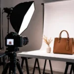 Behind the scenes of a professional product photoshoot showing a studio camera, lighting setup, and product photography workspace.